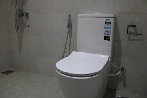 a bathroom with a white toilet in a stall at Exin River Breeze Transit Hotel - Katunayake in Dandugama