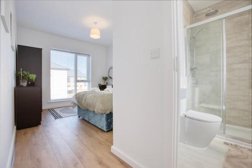 una camera da letto con un letto, una doccia e un bagno di Harveys Yard by Signature Stays - Hayle Luxury Beach home with parking - sleeps 6 a Hayle