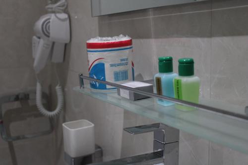 a bathroom with a glass shelf with toothpaste and a phone at Exin River Breeze Transit Hotel - Katunayake in Dandugama
