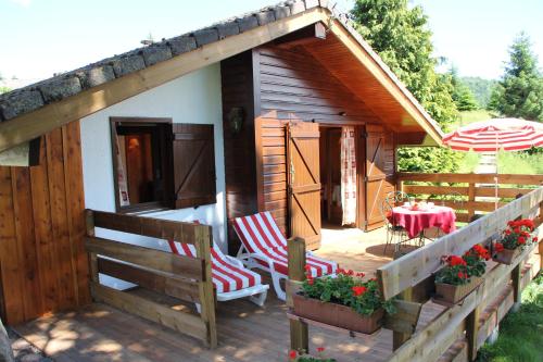 a cabin with a table and chairs and an umbrella at Chalets Julien in Le Thillot