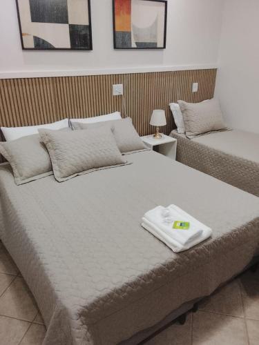 a large bed with a white towel on top of it at Pindorama Golden Plaza Hotel - Pindorama SP in Catanduva