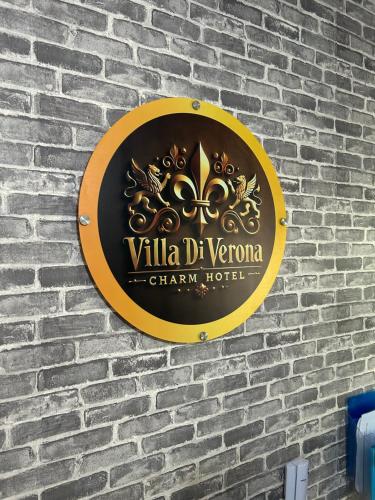 a sign on the side of a brick wall at Villa Di Verona Charm Hotel in Guarujá