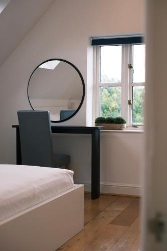a bedroom with a desk with a mirror and a chair at Oxford Nest - Spacious & Luxury Apartments in Oxford
