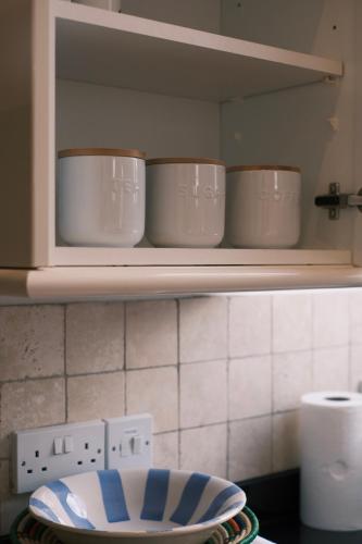 a shelf with three bowls on it in a kitchen at Oxford Nest - Spacious & Luxury Apartments in Oxford