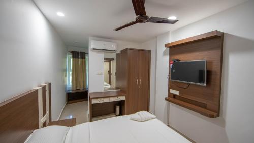 a bedroom with a bed and a tv on a wall at Lilly Ribera in Kumarakom