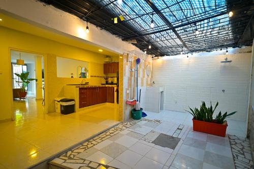 a large room with a kitchen with yellow walls at Tu casa en Cartagena-Torices in Cartagena de Indias