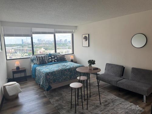 a bedroom with a bed and a table and a chair at Cozy Studio in Houston