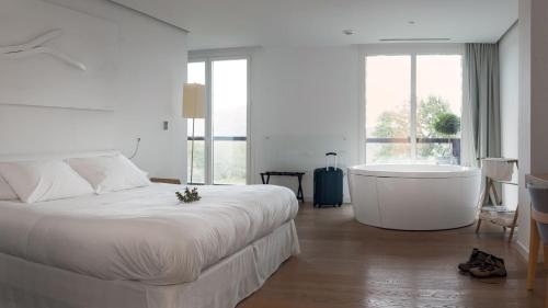 a bedroom with a large bed and a bath tub at Arantza Hotela - Boutique Hotel "Adults Only" in Arantza