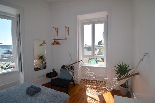 a bedroom with a hammock in a room with windows at Embassy Arriaga Private Elegance Rooms in Stylish Shared Apartment in Lisbon