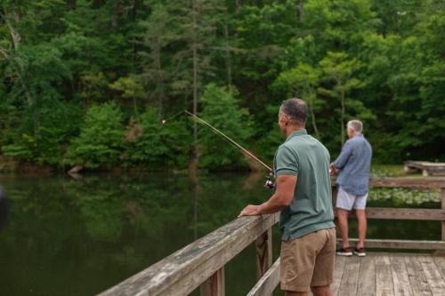 two men standing on a bridge holding a fishing rod at Omni Bedford Springs Resort & Spa in Bedford