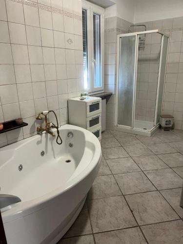 a white bathroom with a tub and a shower at Gina&armando in Cassano Spinola