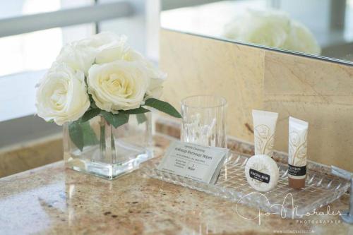 a vase with white roses in it on a table at Lux Aka Brickell Condo in Miami