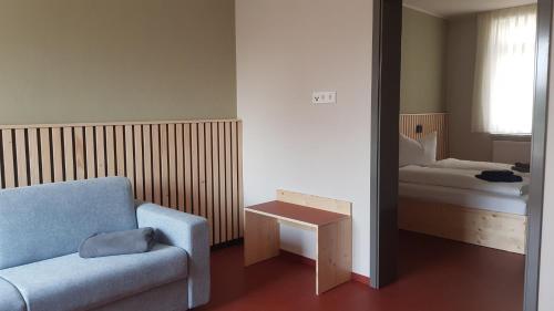 a living room with a couch and a bed at Anna und Sascha, Hotel und Café in Annaberg-Buchholz