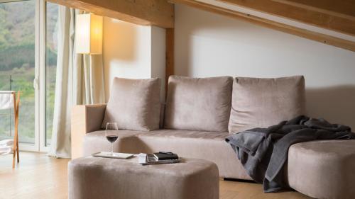 a living room with a couch and a glass of wine at Arantza Hotela - Boutique Hotel "Adults Only" in Arantza