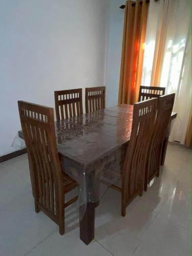 a dining room table with four chairs and a marble table and chairsuggest at Ravi Villa Kandy in Polgolla