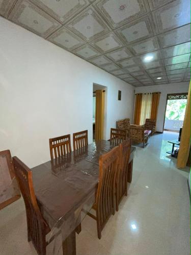 a dining room with a wooden table and chairs at Ravi Villa Kandy in Polgolla