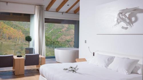a bedroom with a bed and a tub and a window at Arantza Hotela - Boutique Hotel "Adults Only" in Arantza