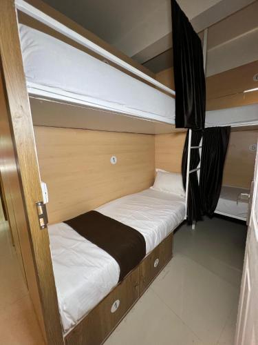 a small bedroom with two beds in it at Lowfare Hotels Medical College in Kozhikode