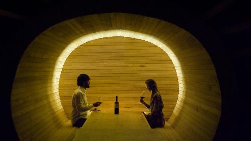 two people standing in a tunnel with a bottle of wine at Arantza Hotela - Boutique Hotel "Adults Only" in Arantza