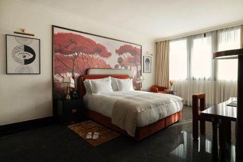 a bedroom with a bed and a large painting on the wall at Marly Boutique Hôtel in Casablanca