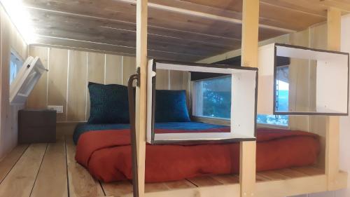 una camera da letto con un letto in una stanza con uno specchio di La Tiny House De Peggy a Sisteron