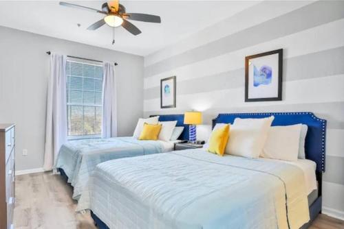 two beds in a bedroom with a ceiling fan at Mickey's Hideaway Windsor Hills Resort in Orlando