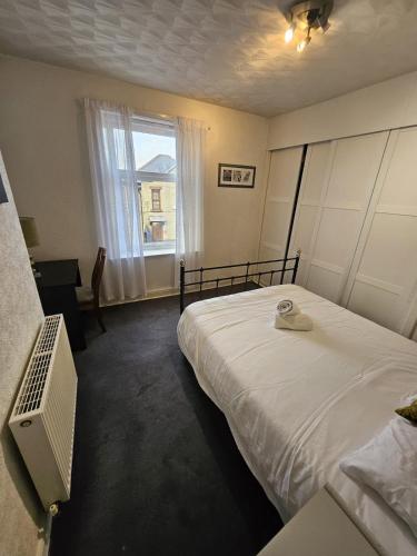a bedroom with a large bed and a window at Large Burnley Townhouse in Burnley