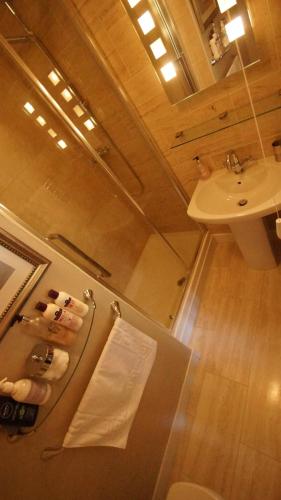 a bathroom with a sink and a toilet and a mirror at The Lychgate in Caldicot
