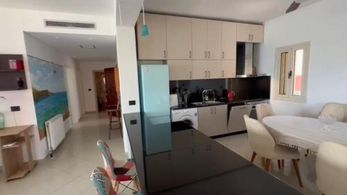 a kitchen and living room with a table and chairs at Manolo & Jolie Luxury Villa in Himare