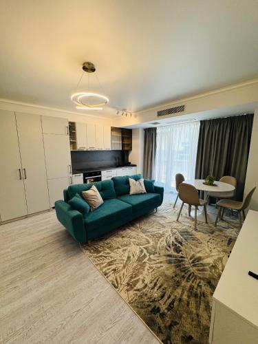 a living room with a green couch and a table at White Titanic -Luxury Turism in Mamaia Sat/Năvodari
