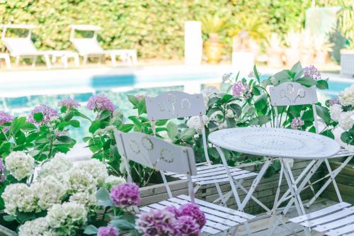 a table and chairs and flowers by a pool at BB Ilde in Villa Verucchio