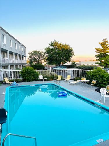 a large blue swimming pool with chairs and a building at Baymont by Wyndham Dayton North in Dayton