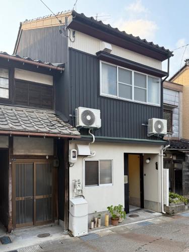 a house with two air conditioners on the side of it at 山二 -Yamafu in Imizu