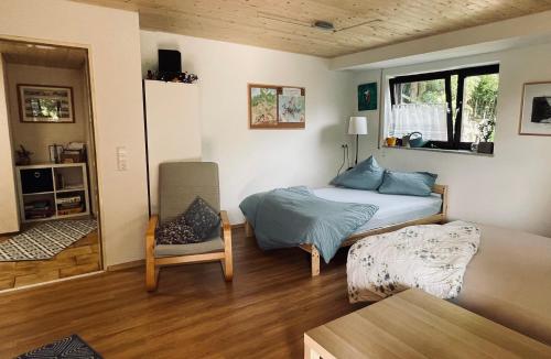 a bedroom with a bed and a chair in it at Glücksmomente in Wolfegg