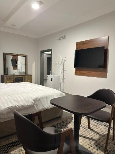 a bedroom with a bed and a table and a tv at فندق ارم in Al Mikhlaf