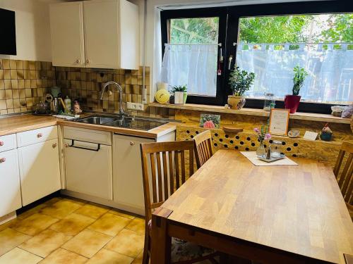 a kitchen with a wooden table and a sink at Glücksmomente in Wolfegg