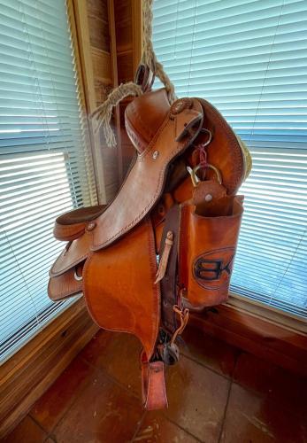 a brown horse saddle hanging on a wall at Private cabin on 100 scenic acres with balcony views in Pipe Creek
