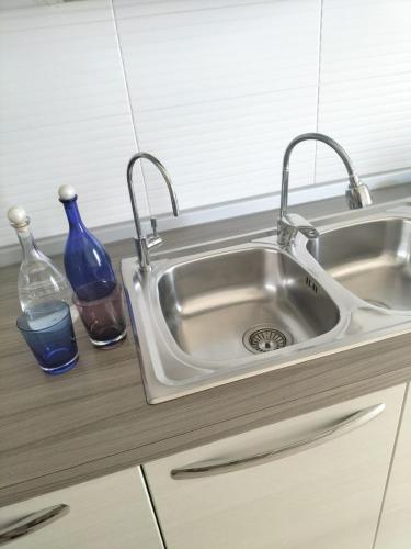 a kitchen sink with two faucets and two bottles at Charme House Trulli, Bari, Polignano, Monopoli 5 star in Turi