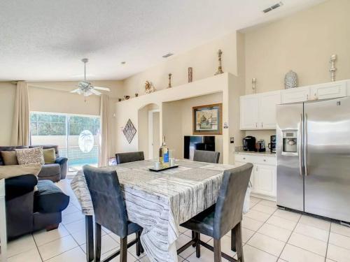 a kitchen with a table with chairs and a refrigerator at Orlando area home w hot tub & pool in Orlando