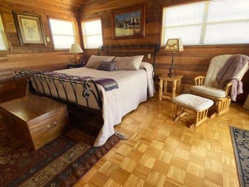 a bedroom with a bed and a chair in a room at Private cabin on 100 scenic acres with balcony views in Pipe Creek