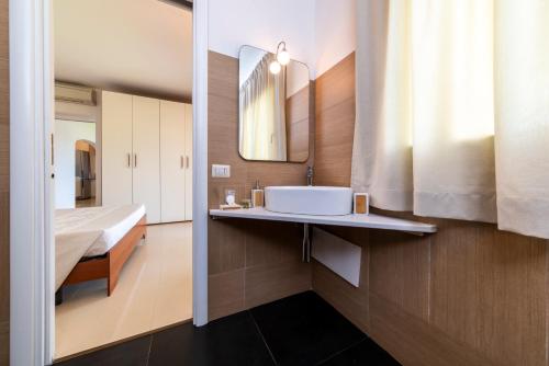 a bathroom with a sink and a mirror at NG Collection gli Oleandri in Liscia di Vacca