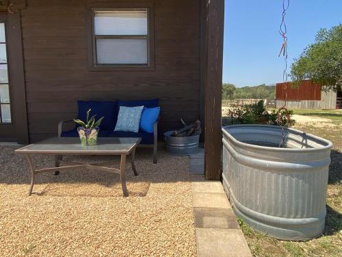 a patio with a couch and a table in front of a house at Private cabin on 100 scenic acres with balcony views in Pipe Creek