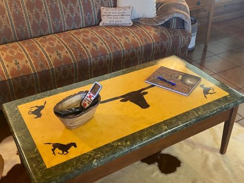 a coffee table with a remote control on top of it at Private cabin on 100 scenic acres with balcony views in Pipe Creek