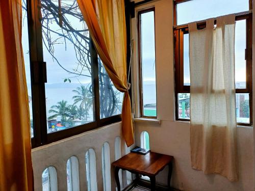 a room with windows and a table with a view of the ocean at Casa Ana Ruth (Bucerias, Nay.) in Bucerías