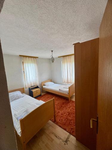a small room with two beds and a door at New Hill house in Visoko