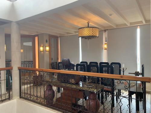 a balcony with chairs and a table and a chandelier at Riad eSSAOUIRA View in Essaouira