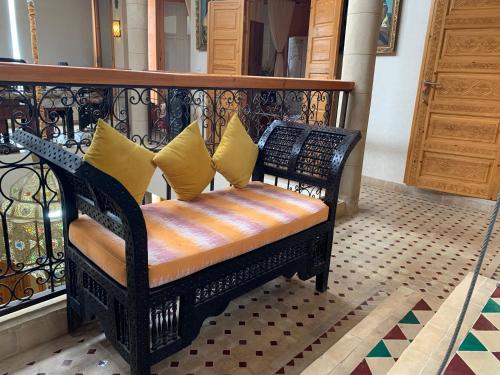 a bench with yellow pillows sitting on a balcony at Riad eSSAOUIRA View in Essaouira