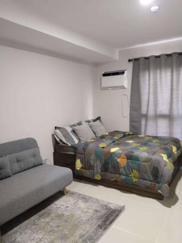 a bedroom with a bed and a couch at Sezuki JTower Stay in Mandaue City