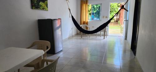 a hammock in a room with a table and chairs at HOTEL CAMPESTRE CRISTALES cerca al mar By AMAUNA in San Bernardo del Viento
