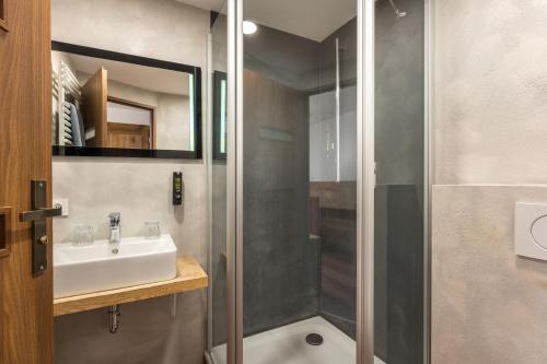 a bathroom with a sink and a shower at Boutique Hotel beim Lipp - Restaurant & Spa in Roßhaupten